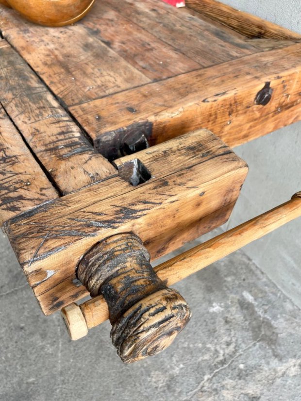 Starý masivní pracovní ponk se dřevěným svěrákem